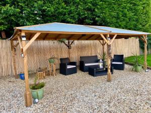 um gazebo de madeira com cadeiras e cadeiras por baixo em Stratford-upon-Avon Family Mansion em Henley in Arden