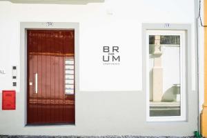 a red door on the side of a white building at Brum Design Apartments in Ponta Delgada