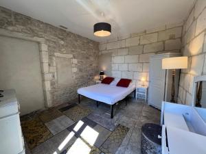 a bedroom with a bed and a stone wall at Hotel Majestic in Nîmes