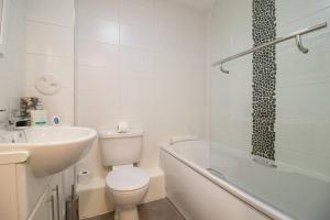 uma casa de banho com um WC, um lavatório e uma banheira em 2 bed flat near airport &parking em Paisley