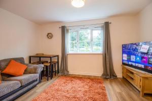 a living room with a couch and a tv at 2 bed flat near airport &parking in Paisley
