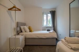 2 bed flat near airport &parking في بيزلي: غرفة نوم صغيرة بها سرير ونافذة