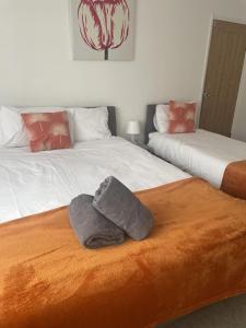 Dos camas con toallas encima. en Immaculate 3-Bed House in Luton, en Luton