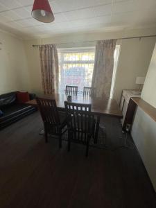 sala de estar con mesa de comedor y sillas en Immaculate 3-Bed House in Luton, en Luton
