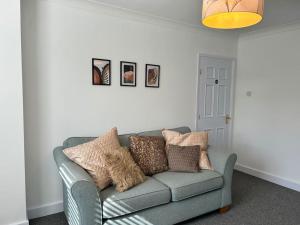 a living room with a gray couch with pillows at Montrose House 3 bedroom home with Parking in Frodingham