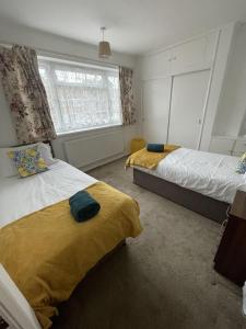 盧頓的住宿－Immaculate 3-Bed House in Luton，一间卧室设有两张床和窗户。