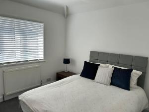 a bedroom with a large bed with blue pillows at Montrose House 3 bedroom home with Parking in Frodingham