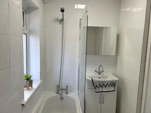 Baño blanco con bañera y lavamanos en Montrose House 3 bedroom home with Parking, en Frodingham