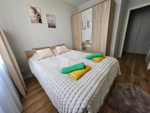 a bedroom with a bed with two pillows on it at Urban Jungle Apartament Brown in Białystok