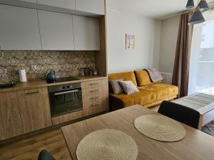 cocina y sala de estar con sofá y mesa en Urban Jungle Apartament Brown, en Białystok