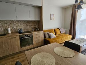 a kitchen and living room with a couch and a table at Urban Jungle Apartament Brown in Białystok