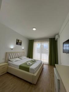 a bedroom with a large bed with green curtains at Apartments Fati & Flori in Ulcinj