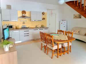 eine Küche und ein Esszimmer mit Tisch und Stühlen in der Unterkunft Casa Vacanza Mare Blu in Villaggio Azzurro