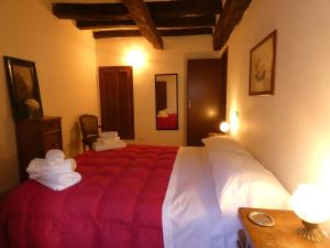 a bedroom with a large bed with a red blanket at SCAPPO IN UMBRIA, nel vicolo in Amelia +14 photos
