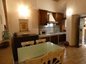 a kitchen with a green table and chairs in it at SCAPPO IN UMBRIA, nel vicolo in Amelia