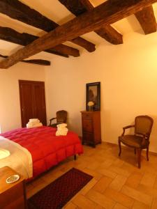 a bedroom with a red bed and two chairs at SCAPPO IN UMBRIA, nel vicolo in Amelia