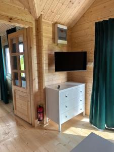 a room with a tv and a dresser in a room at DOMKI NAD STAWEM in Kazimierz Dolny