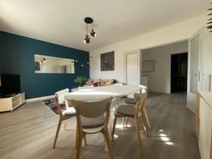 a dining room with a white table and chairs at Appart Lumineux Chaleureux in Montpellier