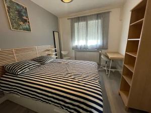 a bedroom with a bed and a desk and a window at Appart Lumineux Chaleureux in Montpellier