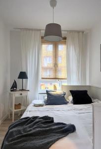 a bedroom with a bed with a blanket on it at White Shell Apartament Hel in Hel
