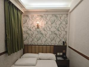 1 dormitorio con 2 camas y pared con papel pintado en Celltronik Hostel 先創旅店, en Hong Kong