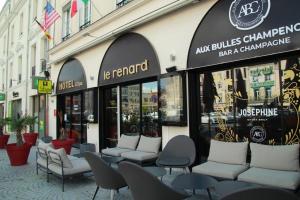 Una fila de sillas frente a un edificio. en HOTEL & SPA Le Renard Centre, en Châlons-en-Champagne