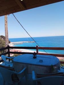 uma mesa azul e cadeiras numa varanda com o oceano em Irida Maria em Agios Ioannis Pelio
