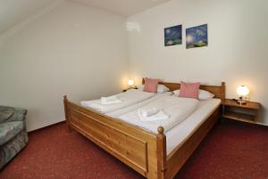 a bedroom with a large wooden bed with pink pillows at Apartment 17 - Ferienresidenz Roseneck, Galeriewohnung, mit Schwimmbad in Todtnauberg bei Feldberg in Todtnauberg