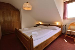 a bedroom with a large bed with white sheets at Apartment 19 - Ferienresidenz Roseneck, mit Schwimmbad in Todtnauberg bei Feldberg in Todtnauberg