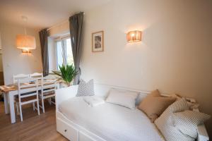 a living room with a white bed and a table at Słone 103 in Kudowa-Zdrój