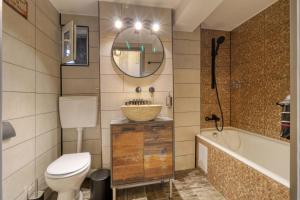 a bathroom with a toilet and a sink and a tub at RDI Elegance Apartment Downtown in Bucharest +44 photos