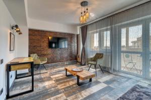 a living room with a table and chairs and windows at RDI Elegance Apartment Downtown in Bucharest