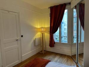 - une chambre avec une fenêtre et une lampe dans l'établissement Aux portes sud de Paris, logement cosy entier, au Kremlin-Bicêtre
