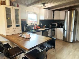 uma cozinha com uma mesa de madeira e um frigorífico em Nice cottage located in Sandvik, 100 meters from a bay em Hagby
