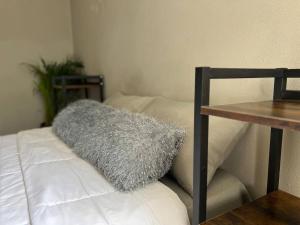 比亞埃爾莫薩的住宿－Torre Polvora Departamento by AIRA Mexico，一张桌子旁白色沙发上的灰色枕头