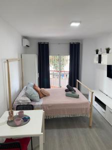 トレモリノスにあるCarolina en Joan Miroの小さなベッドルーム(ベッド2台、テーブル付)