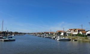 a group of boats docked in a river with houses at La Teste cœur de ville in La Teste-de-Buch +11 photos