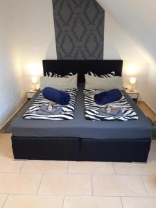 uma cama com duas almofadas azuis em cima em Fewo Haus Morgenstern im Ankerweg em Neuharlingersiel