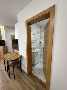 a bathroom with a toilet and a sink and a table at Aparmani Karanovic in Zavidovići