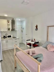 1 dormitorio con 1 cama y cocina con mesa en Carolina en Joan Miro, en Torremolinos