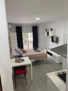 1 dormitorio con 1 cama y 1 mesa en una habitación en Carolina en Joan Miro, en Torremolinos