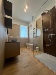 ein Badezimmer mit 2 WCs, einem Waschbecken und einer Dusche in der Unterkunft LA ROSA DEL SILE in Quarto dʼAltino