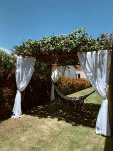eine Hängematte im Garten mit Blumen in der Unterkunft Casalagorios - ilha de Itaparica - Berlinque in Vera Cruz de Itaparica