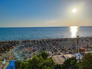 a beach with a lot of umbrellas and the ocean at Hotel Benilva in Durrës