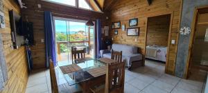 a living room with a glass table in a cabin at Moradas do Maneca in Imbituba