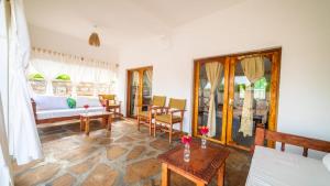a living room with a bed and a table at Villa Clarida in Watamu