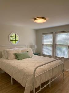 1 cama blanca en un dormitorio con ventana en Whiskey Woods, en Frankfort