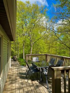 a patio with a table and chairs on a deck at Whiskey Woods in Frankfort