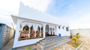 a white house with stairs leading up to it at Villa Clarida in Watamu