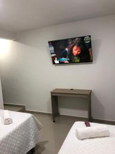 a room with two beds and a tv on the wall at Hotel Ocean Boutique Maicao in Maicao